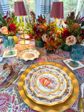 Load image into Gallery viewer, Turkey & Gourds: Thanksgiving Table for 16 set on a patterned tablecloth with gold chargers, teal glasses, and floral centerpieces with candles, featuring paper plates decorated with pumpkin illustrations.