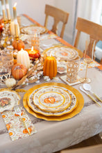 Load image into Gallery viewer, The Turkey & Gourds Table Setting by Sophistiplate features designer plates, gold chargers, candles, decorative pumpkins, glassware, and cutlery on a floral tablecloth with a festive fall centerpiece.