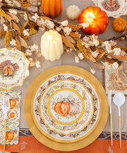 Load image into Gallery viewer, Create a warm and inviting Thanksgiving tablescape with the Turkey &amp; Gourds Table Setting by Sophistiplate, featuring pumpkin-themed designer paper plates, gold chargers, faux pumpkins, candles, a floral garland, and vintage turkey napkins. White and gold flatware is arranged beside each place setting atop an orange tablecloth for a festive autumn look.
